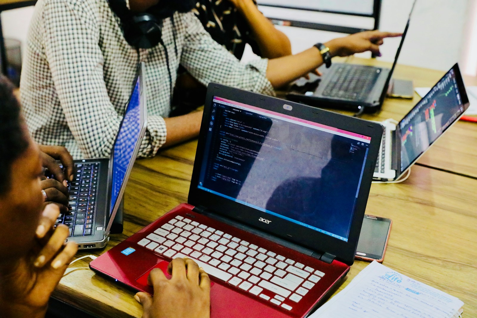 person using black and red Acer laptop computer on table